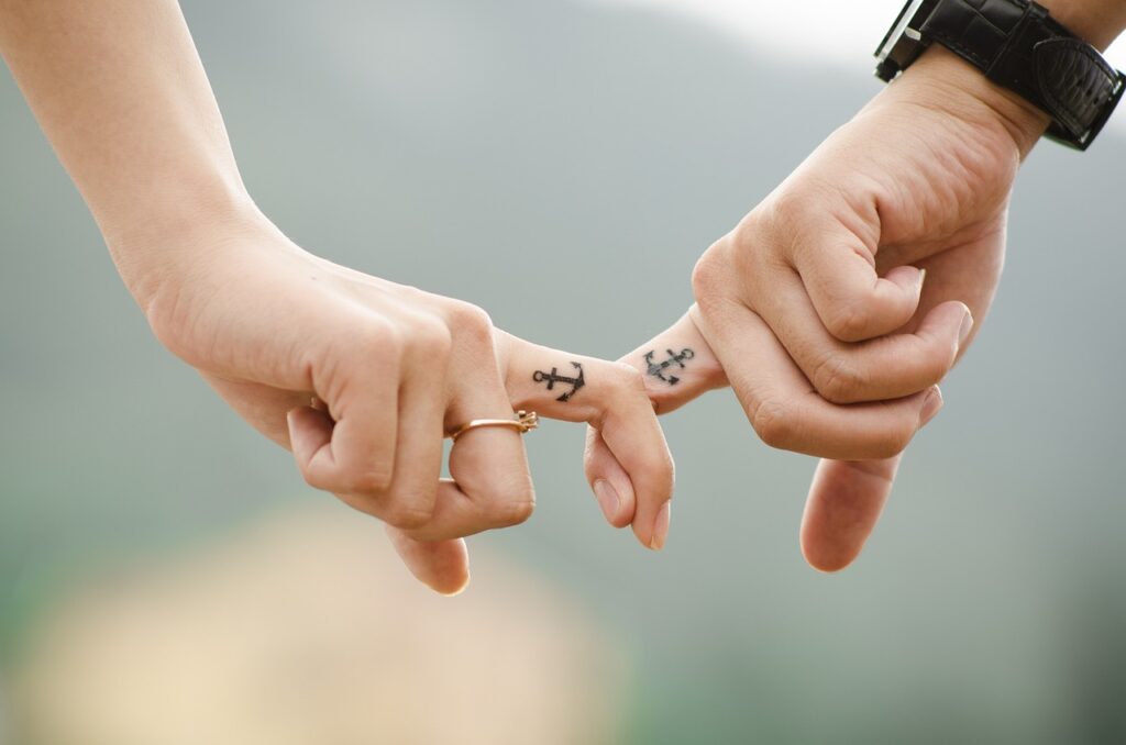 couple holding fingers with cute tattoo